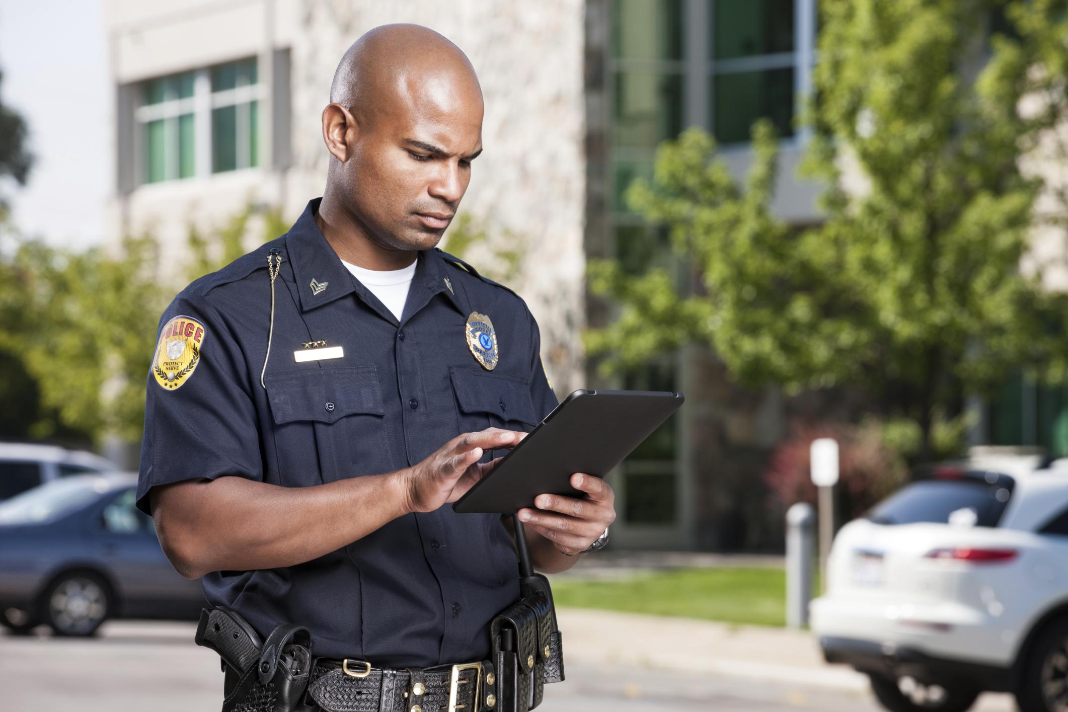Policier utilisant une tablette gérée et sécurisée par SOTI ONE Platform